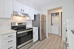 Portage apartment for rent - A kitchen with white cabinets and a stainless steel refrigerator.