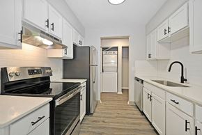 Portage apartment for rent - A kitchen with white cabinets and black appliances.