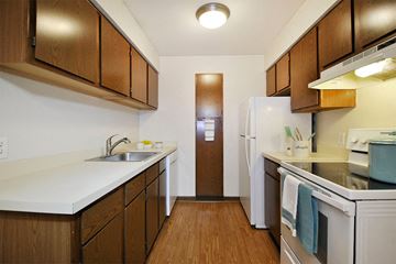 Farmington Hills apartment for rent - A kitchen with brown cabinets and a white fridge.