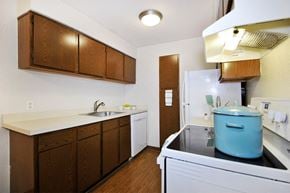 Farmington Hills apartment for rent - A kitchen with a white fridge and a blue pot on the stove.