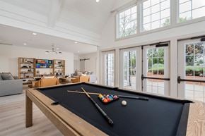 Centerville apartment for rent - A pool table with a black cloth and a cue stick on it.