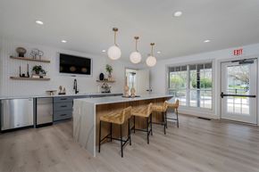 Centerville apartment for rent - a large kitchen with an island and chairs in front of a door