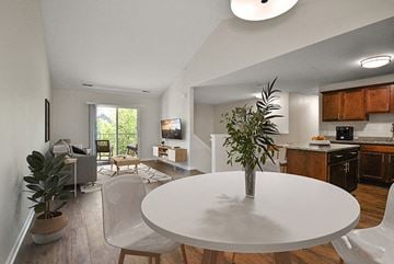 Shelby Township apartment for rent - a living room and dining room with a white table and a plant