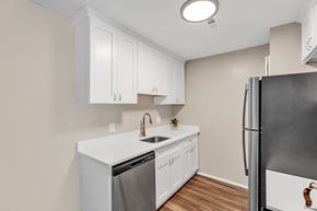 Farmington Hills apartment for rent - A kitchen with white cabinets and a black refrigerator.