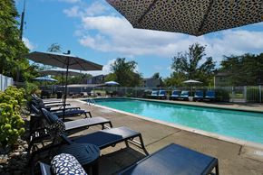 Farmington Hills apartment for rent - A pool area with sun loungers and umbrellas.