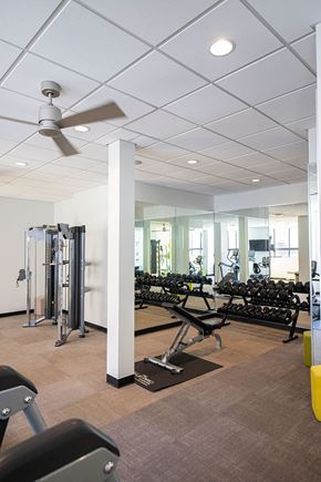 Detroit apartment for rent - A gym with a variety of equipment including weights and a treadmill.