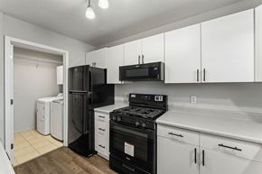 Bentonville apartment for rent - A kitchen with black appliances and white cabinets.