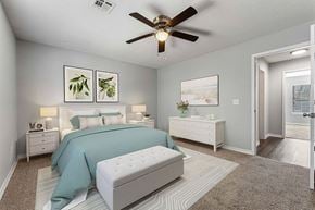 Bentonville apartment for rent - A bedroom with a bed, nightstand, and a ceiling fan.