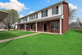 Bentonville apartment for rent - A red brick building with white trim and a black door.