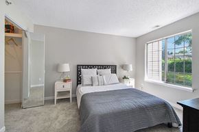 Troy apartment for rent - A bedroom with a large bed and a window with blinds.