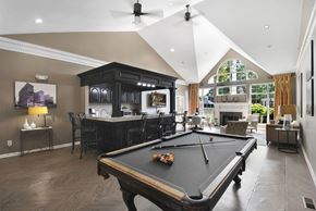 Troy apartment for rent - A pool table is in the middle of a room with a bar and a fireplace.
