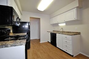Saginaw apartment for rent - a kitchen with black appliances and white cabinets