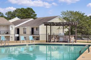 Little Rock apartment for rent - A swimming pool with a slide and chairs in front of a house.