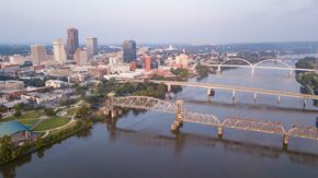 Little Rock apartment for rent - A bridge spans a river in a city with a skyline in the background.