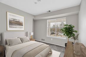 Canton apartment for rent - A bedroom with a large bed and a painting on the wall.