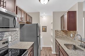 Canton apartment for rent - A kitchen with a stove top oven, microwave, refrigerator, and sink.