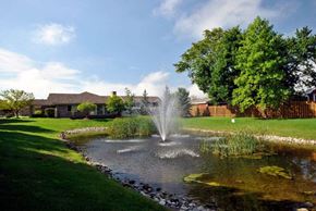 South Rockwood apartment for rent - A fountain in the middle of a pond surrounded by grass and trees.