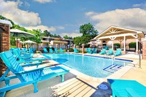 Little Rock apartment for rent - A pool area with blue chairs and a white pavilion.