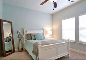 Myrtle Beach apartment for rent - A bedroom with a bed, a mirror, and a ceiling fan.