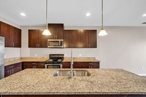 Detroit apartment for rent - A kitchen with brown cabinets and a granite countertop.