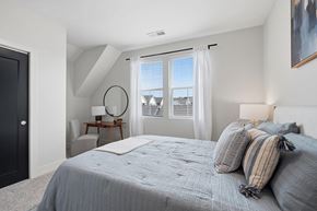 Perrysburg apartment for rent - A bedroom with a large bed and a view of the outside through the window.
