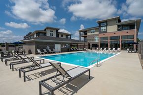 Charlestown apartment for rent - A swimming pool with sun loungers in front of a modern building.
