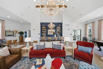 Perrysburg apartment for rent - A living room with a red couch and a chandelier.