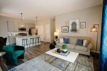 Columbus apartment for rent - A living room with a white couch and a green chair.