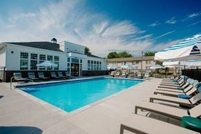 Columbus apartment for rent - A large swimming pool area with sun loungers and a building in the background.