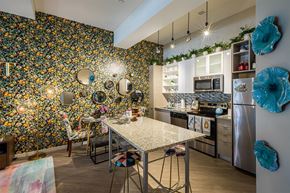Detroit apartment for rent - A kitchen with a table and chairs in front of a wall covered in flowers.