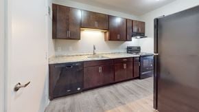 Racine apartment for rent - a kitchen with wooden cabinets and a stainless steel refrigerator