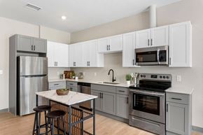 Cleveland apartment for rent - a kitchen with white cabinets and stainless steel appliances