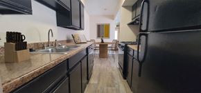 Asheville apartment for rent - a kitchen with black appliances and counters and a dining room with a table