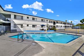 Tustin apartment for rent - A swimming pool is located in front of a building.