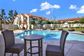 Fullerton apartment for rent - A table and two chairs are set up by a pool.