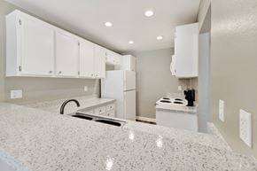 Fullerton apartment for rent - A kitchen with white cabinets and a granite countertop.