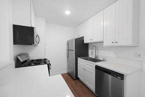 Anaheim apartment for rent - a kitchen with white cabinetry and black appliances