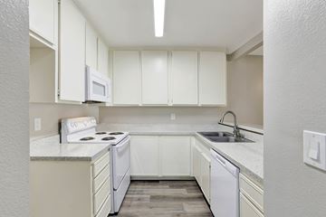 Santa Ana apartment for rent - A kitchen with white cabinets and appliances.