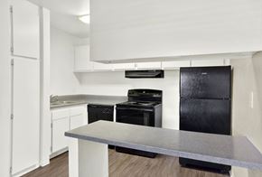 Colton apartment for rent - A modern kitchen with black appliances and white cabinets.