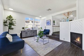 Placentia apartment for rent - A living room with a blue chair and a fireplace.