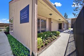 Placentia apartment for rent - Leasing office entrance with signage and garden at ELEVATE Apartments HOMES, Placentia, 92870