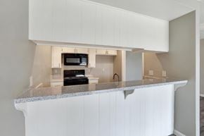 Fountain Valley apartment for rent - A kitchen with white cabinets and a granite countertop.
