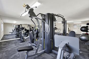 A gym with a variety of equipment including a leg press machine.