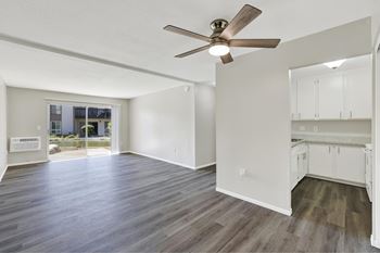 A room with a ceiling fan and wooden flooring.