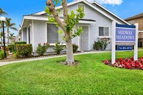 Midway City apartment for rent - A tree stands in front of a sign for Midway Meadows.