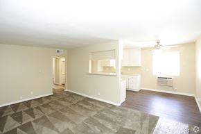 Orange apartment for rent - A spacious room with a ceiling fan and a window.