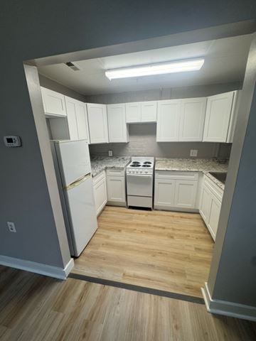 Baltimore apartment for rent - A kitchen with white cabinets and a wooden floor.