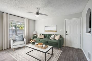 El Paso apartment for rent - A living room with a green couch and a white chair.