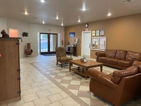 El Paso townhouse for rent - A waiting room with brown leather couches and a wooden door.