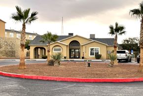 El Paso townhouse for rent - A building with a red border around it and palm trees in front.
